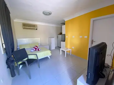 a living room with a bed and a tv at Hurghada-Magawish Studio 1 in Hurghada