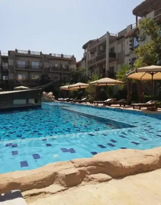 a large swimming pool with chairs and umbrellas at Hurghada Jungle Clube House Compound 1 bedroom Хургада компаунд студия в Джангл с 1 спальней in Hurghada