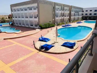 a swimming pool with blue lounge chairs on a building at Cecilia resort hurghadaمنتجع سيسيليا in Hurghada