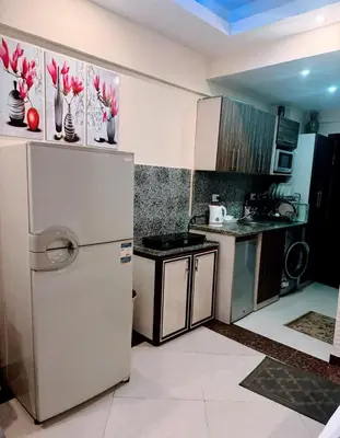 a kitchen with a white refrigerator and a stove at Cecilia resort hurghadaمنتجع سيسيليا in Hurghada