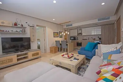 a living room with a couch and a tv at Ollystays Mangroovy 1 BR Beach and Pool Free access in Hurghada