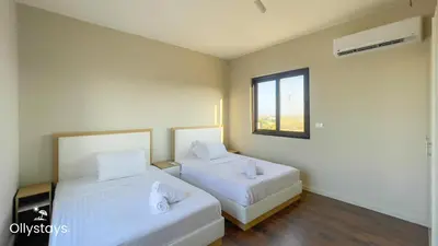 two beds in a room with a window at Ollystays 4BR Townhouse Shared Pool El Gouna in Hurghada