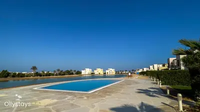 an empty swimming pool with buildings in the background at Ollystays 4BR Townhouse Shared Pool El Gouna in Hurghada