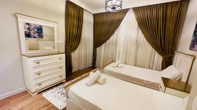 a bedroom with two beds and a dresser and a television at Ollystays 4BR Villa Heated Pool El Gouna in Hurghada