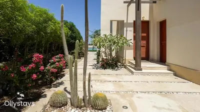 a garden with cacti and flowers next to a building at Ollystays 4BR Villa Heated Pool El Gouna in Hurghada