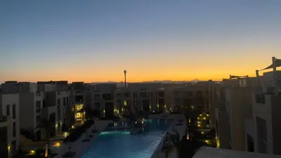 a view of a pool in a city at sunset at Ollystays Mangroovy Seaview 2BR Beach and Pool Free access in Hurghada