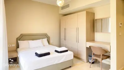 a small bedroom with a bed and a desk at Ollystays Mangroovy Seaview 2BR Beach and Pool Free access in Hurghada