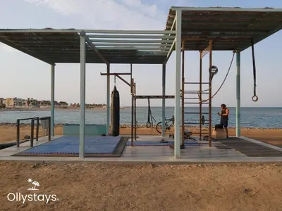 a person sitting on a swing at the beach at Ollystays Mangroovy Seaview 2BR Beach and Pool Free access in Hurghada