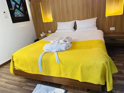 a bed with a yellow blanket and a stuffed animal on it at Farida Djorf Palce in Luxor