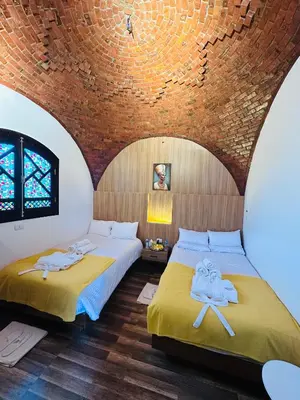 two beds in a room with a brick wall at Farida Djorf Palce in Luxor