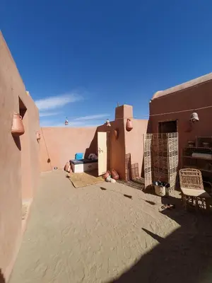 a person sitting in the sand in the desert at Massel Belosso in Aswan