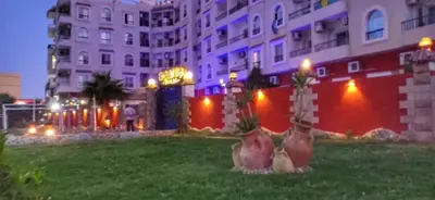 a large building with palm trees in the grass at منتجع اباظة السياحى in Hurghada