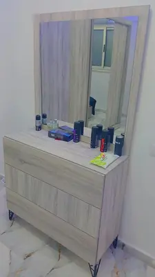 a wooden dresser with a mirror on top of it at اهلا بيكم في بيتنا in Jazīrat al ‘Awwāmīyah
