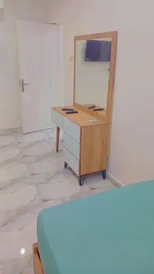a dresser with a mirror on top of it at اهلا بيكم في بيتنا in Jazīrat al ‘Awwāmīyah