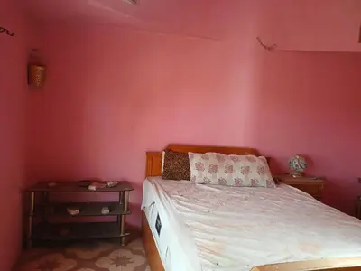 a bedroom with a bed and a pink wall at Habu view in Al Karnak
