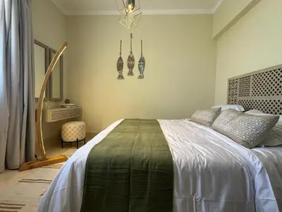 a bedroom with a large bed and a chandelier at Your Red Sea Hideaway Apartment in Coraya Bay