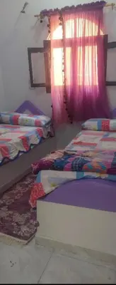 a bedroom with two beds and a window at Rozan Guest house Aswan in Jazīrat Aswān