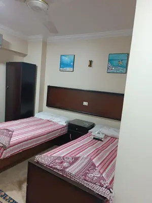 two beds in a hotel room with two beds at فندق الإيمان El Eman Hotel in Maḩaţţat Idfū