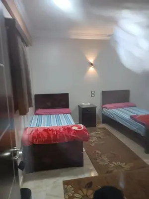 a bedroom with two beds in a room at فندق الإيمان El Eman Hotel in Maḩaţţat Idfū
