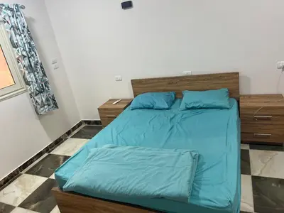 a bedroom with a bed with blue sheets at Dream apartment2 in Hurghada