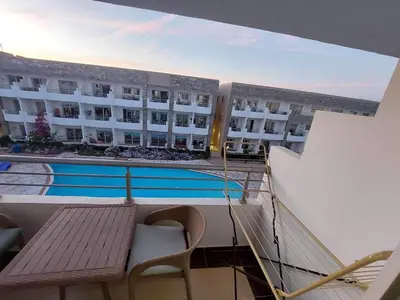 a balcony of a hotel with a bench and a swimming pool at Cecilia resort منتجع سيسيليا in Hurghada