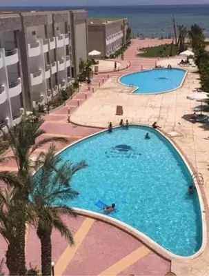 an overhead view of a large swimming pool next to the beach at Cecilia resort منتجع سيسيليا in Hurghada