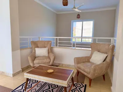 a living room with two chairs and a coffee table at Sylvie guest house in Luxor