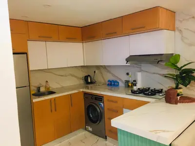 a kitchen with wooden cabinets and a washing machine at Fanadir Bay in Hurghada