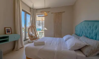 a bedroom with a bed with a blue headboard and a window at Luxury Villas in Tawila El Gouna in Hurghada