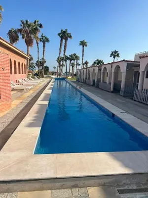 a blue swimming pool with palm trees in the background at Mashrabiya hotel in Hurghada