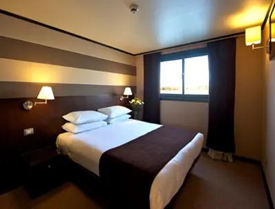 a hotel room with a large bed and a window at Nile Cruise FB 3 Nights Aswan Luxor in Aswan