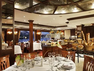 a dining room with tables and chairs in a restaurant at Nile Cruise FB 3 Nights Aswan Luxor in Aswan