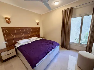 a bedroom with a purple bed and a window at Sheherazade Hotel Nile Villa in Luxor
