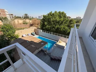 a view of a swimming pool from a balcony at Sylvie guest house I in Luxor