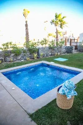 a small swimming pool with a basket in the grass at 4 Bedrooms, Luxury Villa Makadi Heights in Hurghada