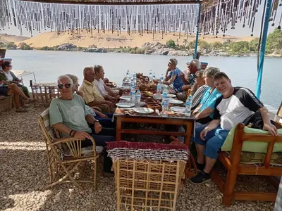 a group of people sitting around a long table at Nile Bride in Aswan