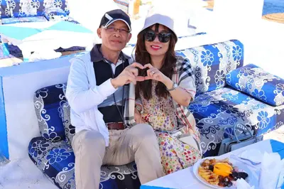 a man and a woman posing for a picture with a plate of food at Kulaih nubian guest house in Aswan