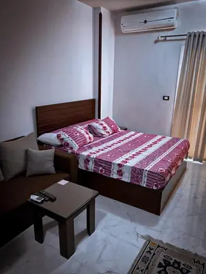 a bedroom with a bed and a couch and a table at Tiba A F B View in Hurghada