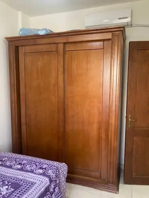 a wooden cabinet in a room with a bed at M-2bedroom flat with garden in Hurghada
