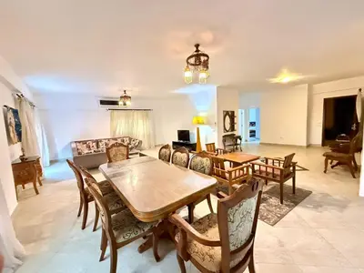 a living room with a table and chairs at Spacious 3BR Apartment - Al Dora Resort, Hurghada in Hurghada