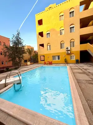 a swimming pool in front of a building at Spacious 3BR Apartment - Al Dora Resort, Hurghada in Hurghada