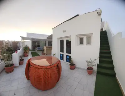 a balcony of a house with a table and stairs at White Roof - Hurghada in Hurghada