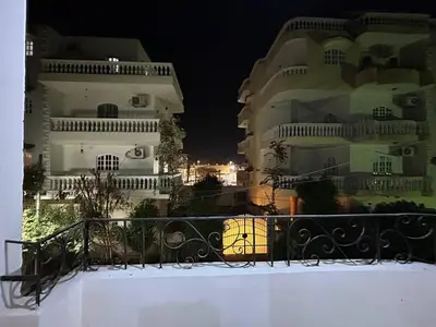a view of two large white buildings at night at The Nile flat in Luxor