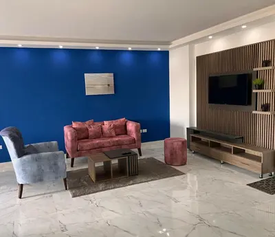 a living room with a red couch and a blue wall at Modern Retreat with Red Sea View - Fanadir bay in Hurghada