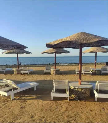 a group of chairs and umbrellas on a beach at Modern Retreat with Red Sea View - Fanadir bay in Hurghada