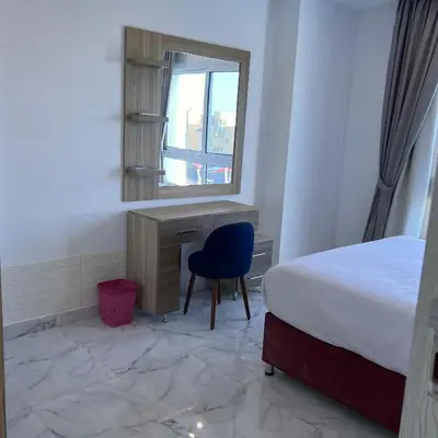 a bedroom with a bed and a desk and a mirror at Modern Retreat with Red Sea View - Fanadir bay in Hurghada