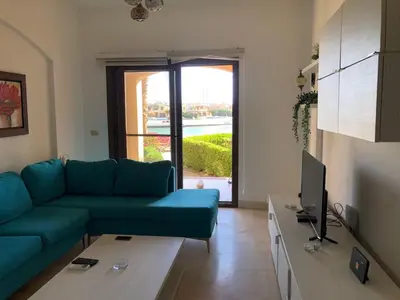 a living room with a blue couch and a tv at one bedroom ground floor sabina elgouna in Hurghada