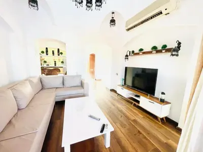 a white living room with a couch and a tv at 5 bedroom villa with private pool west golf elgouna in Hurghada