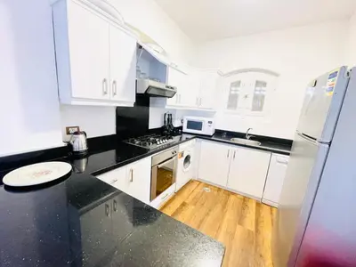 a kitchen with white cabinets and a black counter top at 5 bedroom villa with private pool west golf elgouna in Hurghada