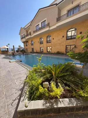 a building with a swimming pool in front of a building at Aqua blue bay in Hurghada